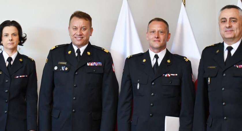 Zdjęcie pamiątkowe nowo powołanego Zastępcy Komendanta Powiatowego PSP. Od lewej na tle flag państwowych stoją: bryg. Iwona Kozicka, nadbryg. Jarosław Nowosielski, mł. bryg. Karol Kuras, st. bryg. Leszek Szcześniak